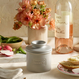Butter Bell Crock cafe matte stone gray ceramic with lid on a kitchen table beside bread and vegetables