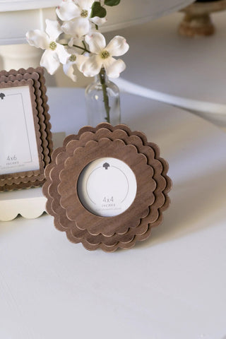 Espresso wood scalloped photo frames (two pieces: round 4x4 and square 4x6) on a white surface with a vase of flowers
