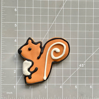 All the Dog Things Dapper squirrel-shaped cookie in orange with black outline and white tail, Lucky Biscuit Pet Bakery