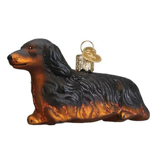 Long-haired dachshund ornament in brown and black with glitter accents and a gold hanging loop.