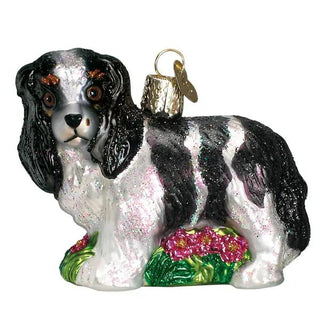 King Charles Spaniel ornament in black and white with glitter, on a green base with pink flowers