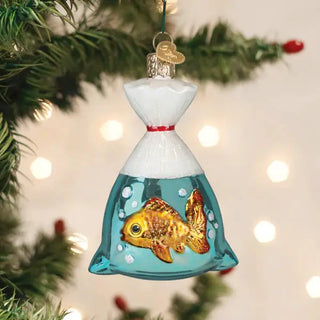 Goldfish in a Bag ornament, glass pendant with teal water and goldfish, white top, red ribbon, hanging on a Christmas tree