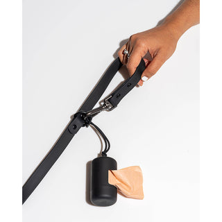 Poop bag carrier dispenser in black attached to a leash with a metal clip