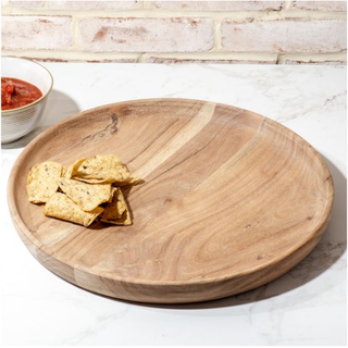 Round Acacia wood snack tray with tortilla chips, natural finish.