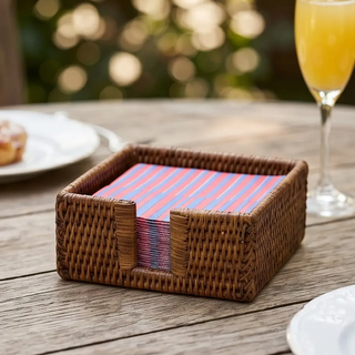 Rattan cocktail napkin holder, natural brown with red and blue striped napkins.
