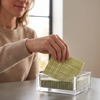 Acrylic cocktail napkin holder by Caspari, clear with green geometric-patterned napkins