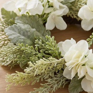 Candle ring with mixed foliage and white hydrangea, artificial greenery in ivory and sage greens.