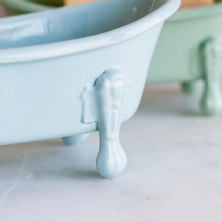 Bathtub soap dish in light blue ceramic with clawfoot legs.