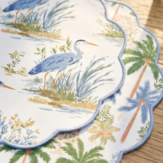 Placemats set of 4 with tropical heron and palm motifs; reversible with pale blue scalloped edging.