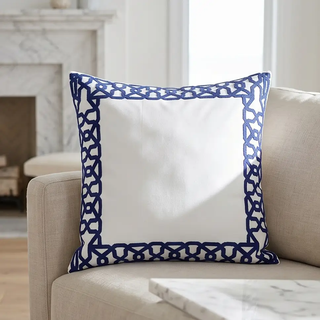 Square white pillow with blue applique border for a decorative touch.