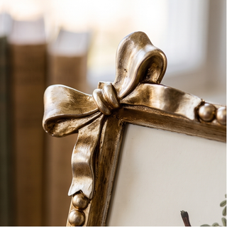 Antique gold bow frame, decorative picture frame with ribbon bow and bead accents.