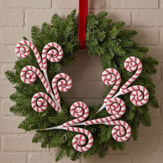 Peppermint Swirl Spray holiday wreath with red-and-white candy cane spirals on green evergreen foliage.
