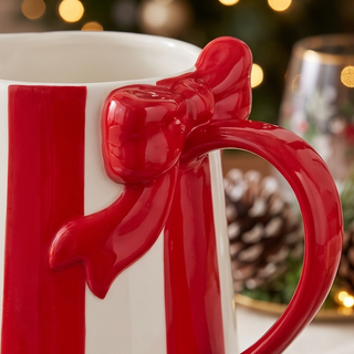 Striped bow pitcher with red handle and bow accent on white body, serving pitcher