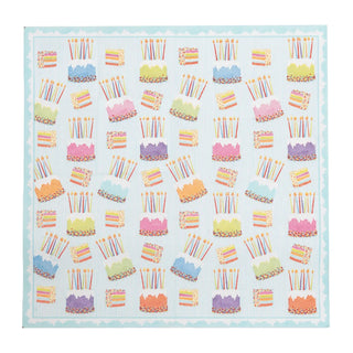 Luncheon napkin with cake frosting motif; pastel cakes with candles on a light blue striped background.