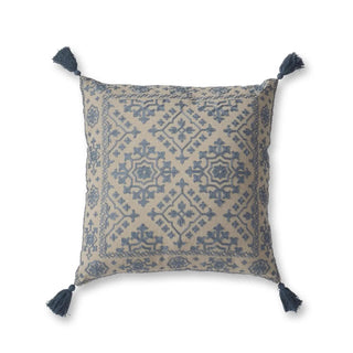 Square beige pillow with blue embroidery and blue tassels at each corner.