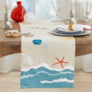 Beach table runner on beige linen with blue wave border and seashell/starfish motifs.