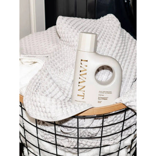 Laundry detergent bottle, Fresh Linen, white plastic with built-in handle among white towels.