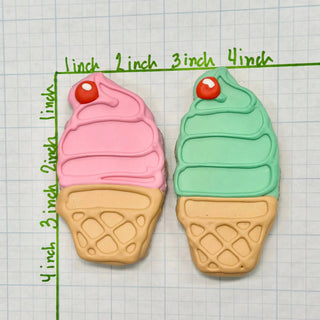 Dapper lunch menu cookies, two pastel pink and mint green treats with red icing eyes