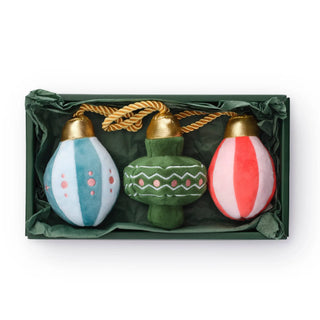 Dog toy set in a green gift box with three ornament-shaped plush toys in blue, green, and pink-red.