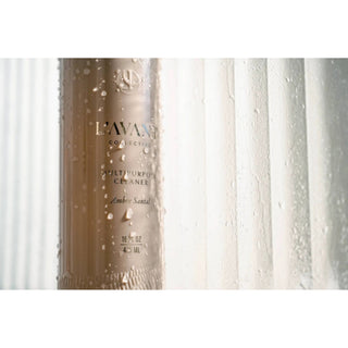 Multipurpose cleaner Ambre Santal in a beige bottle with droplets and an embossed logo.