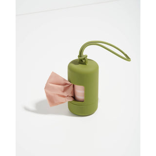 Olive green poop bag dispenser with pink bag protruding and a cord handle