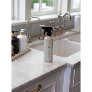 Fresh Linen multipurpose cleaner bottle with a black spray nozzle on a white marble kitchen counter