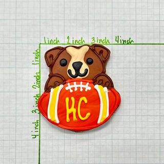Sports Ball Buffet Cookies, dog-shaped cookie with brown and cream holding an orange football with yellow KC initials