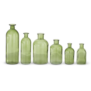 Green glass bottles in six varying heights arranged in a row
