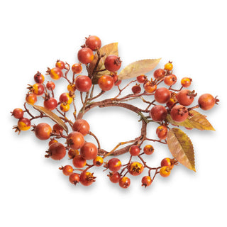 Rosehip candle ring with orange-red berries on brown stems and autumn leaves against a white backdrop.
