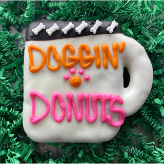 DOGGIN’ DONUTS coffee dog treats mug-shaped cookie with orange DOGGIN’ and pink DONUTS icing