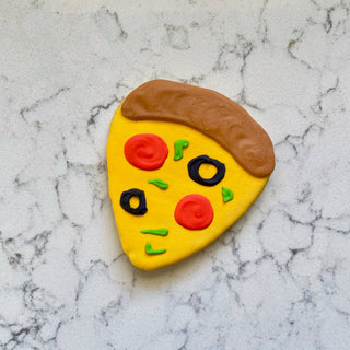 Lunch Menu Dapper pizza-shaped dog treat with a yellow base, brown crust, red pepperoni, black olives, and green toppings