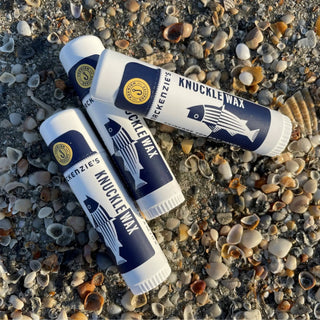 Hand Ritual Favorites Bundle — Opal and Olive knuckle wax tubes (4) in navy packaging on a shell-strewn beach