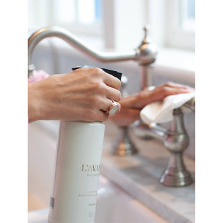 White Fresh Linen multipurpose cleaner spray bottle being sprayed into a kitchen sink by hands.