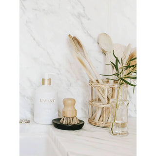 Fresh Linen dish soap bottle with a gold pump on a white marble countertop.