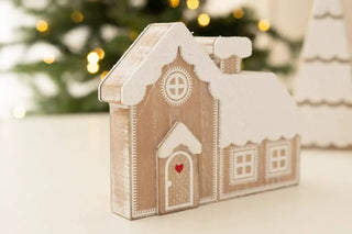 Wooden house-shaped Christmas ornament with snow accents and a red heart on the door
