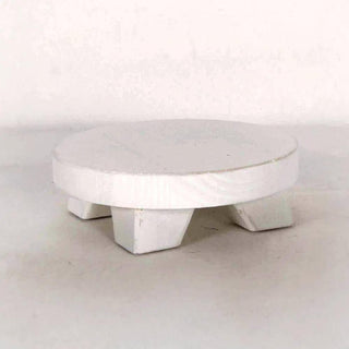 Round mini wood riser in white finish with three short legs for display.