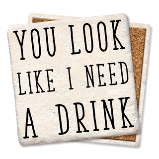 Coasters, 2-pack, with beige textured tops and cork backs reading YOU LOOK LIKE I NEED A DRINK.