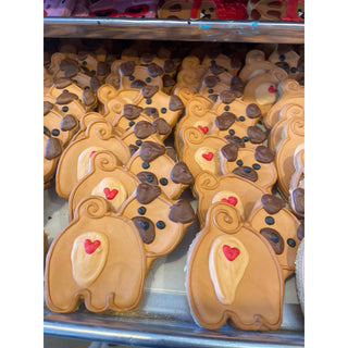 All the Dog Things Dapper dog-shaped cookies with tan icing and red heart accents; dozens shown.