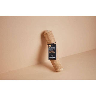 Dog chew stick made of coffee wood with a black label tag