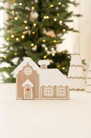 Chunky wooden house ornament with snow-dusted roof in beige finish.