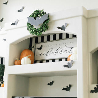 Black paper bat cutouts, 16 pcs, Halloween shelf decor with pumpkins.