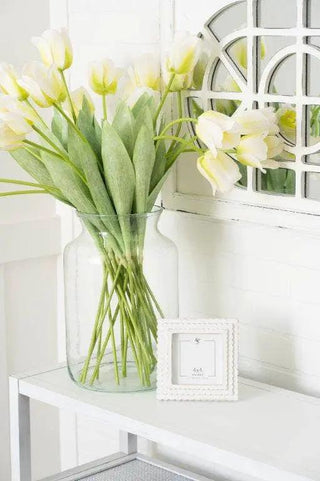 Wood scalloped photo frame for 4x4 pictures, white, on a white table beside a glass vase with tulips.