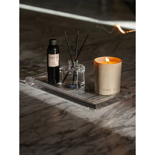 Ambre Santal candle with glass reed diffuser and scent bottle on a clear acrylic tray