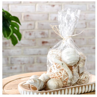 Bleached wood bowl filler bag with white wood shavings in a clear plastic bag tied with twine