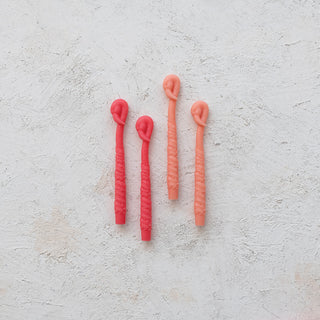 Flamingo-shaped taper candles set of 4 in peach and pink, unscented.