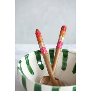 Set of 2 salad servers with colorful rattan-wrapped wooden handles in a green-striped ceramic bowl.