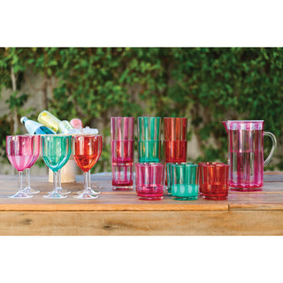 2-1/2 qt acrylic striped pitcher with lid in fuchsia, paired with assorted colorful glassware on a wooden table
