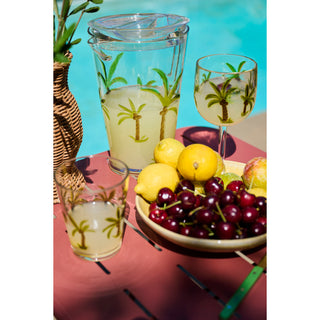 Acrylic Pitcher with Palm Trees & Lid, clear palm-tree motif; includes two matching glasses on an outdoor table