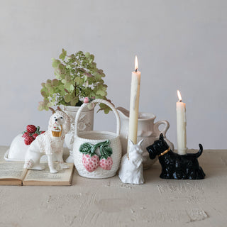 Two ceramic Scottie dog taper holders in white and black with gold collars, displayed with candles.