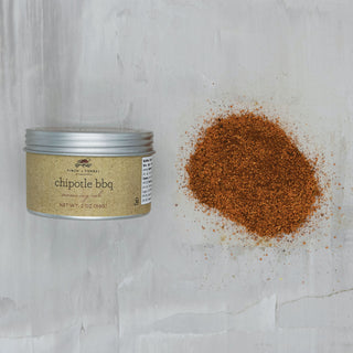 Chipotle BBQ seasoning in a metal tin beside a mound of reddish-brown spice.